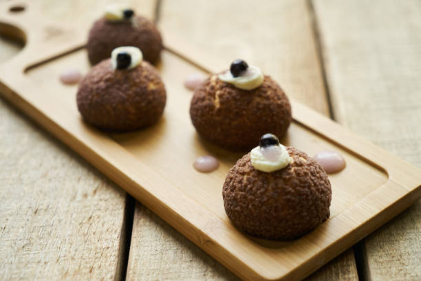 istock White chocolate profiteroles with peach violet. Cake 1037330820