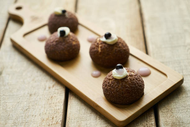 istock White chocolate profiteroles with peach violet. Cake 1037330826