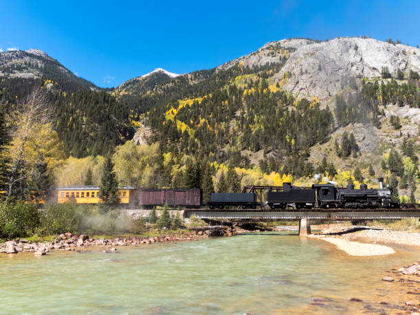 The Durango & Silverton Narrow Gauge Railroad (D&SNG) travels between Durango, Colorado and Silverton, Colorado with its vintage steam locomotives. This is in the San Juan Mountains and near the Animas River. These great excursion passenger trains are enjoyed by a large number of people each day, with most starting from the Durango Depot. Photo edited to remove names and numbers.