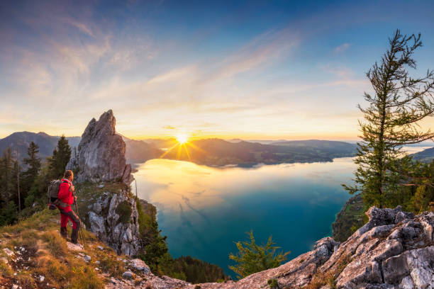mountain climber at sunset with view to lake attersee from schober- sunset at mount schoberstein, alps - austria mountain peak mountain panoramic imagens e fotografias de stock