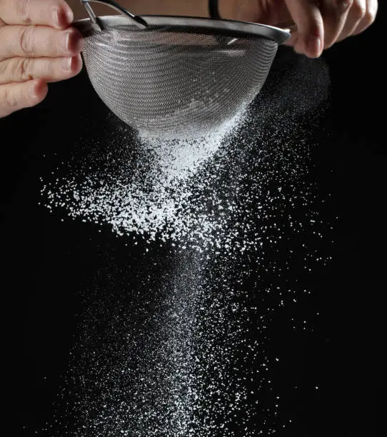 fluffy powdered sugar on black background
