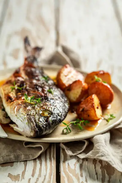 Tasty potatoes and seabream with herbs and tomatoes