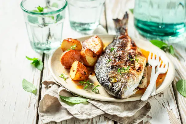Grilled potatoes and seabream with herbs and tomatoes