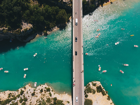 Scenic aerial view of boats on  Verdon lake and cars on the bridge