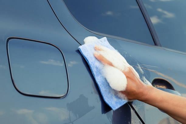 istock A female hand with sponge in soapy foam washes the car 1037378466