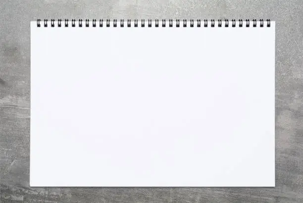 Photo of Blank page of a sketchbook over gray surface