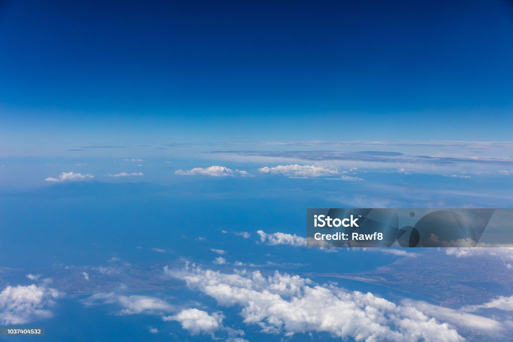 Cloudscape background. View out of an airplane window. Cloudy sky background. View out of an airplane window. Above Stock Photo