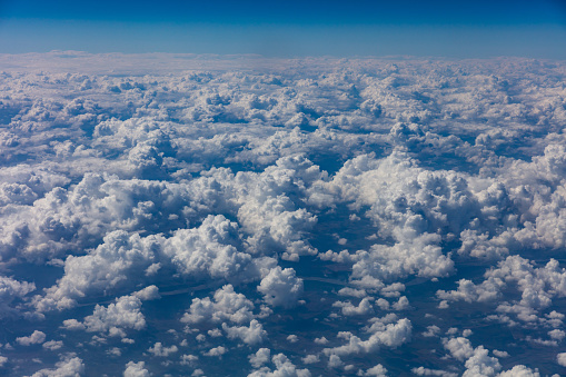 Cloudy sky background. View out of an airplane window.