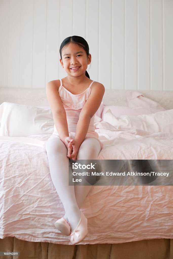Asian girl in ballet costume sitting on bed  Ballet Dancer Stock Photo