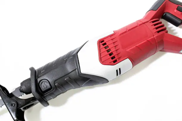 Photo of Red reciprocating saw with a blade isolated in a white background composition