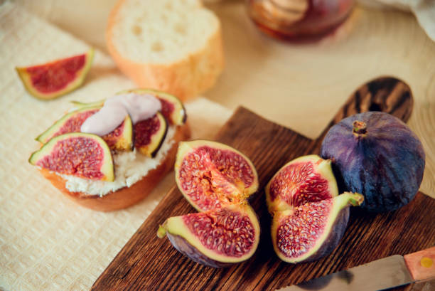 istock Autumn dessert: bruschetta with ripe figs, soft cheese and honey on a light background. 1037449490