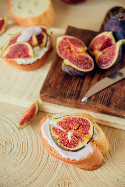 istock Autumn dessert: bruschetta with ripe figs, soft cheese and honey on a light background. 1037449494
