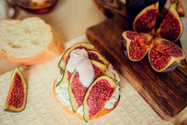 istock Autumn dessert: bruschetta with ripe figs, soft cheese and honey on a light background. 1037449514