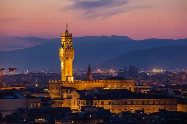 Photo of Beautiful view of Palazzo Vecchio in evening illumination and the river Arno