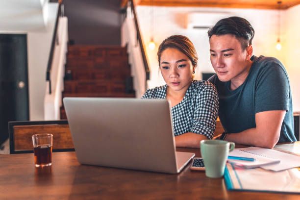 istock Serious couple using laptop while sitting at home 1037487434