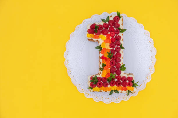 istock cake in shape of number one on a yellow background 1037498080