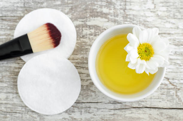 mała biała miska z olejkiem kosmetycznym/oczyszczającym i wacikiem do naturalnej pielęgnacji skóry. domowe kosmetyki. - chamomile plant daisy spa treatment chamomile zdjęcia i obrazy z banku zdjęć