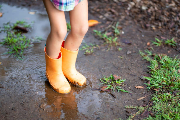 istock Children's feet to play with a puddle 1037506520