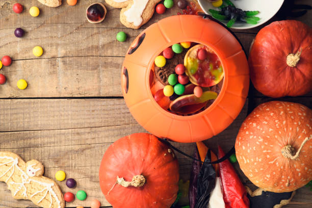istock Halloween candies on wood table - holiday background 1037524950