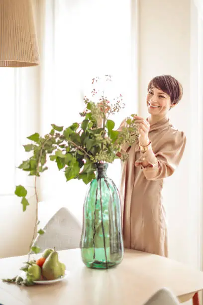 Woman is arranging her flowers at home