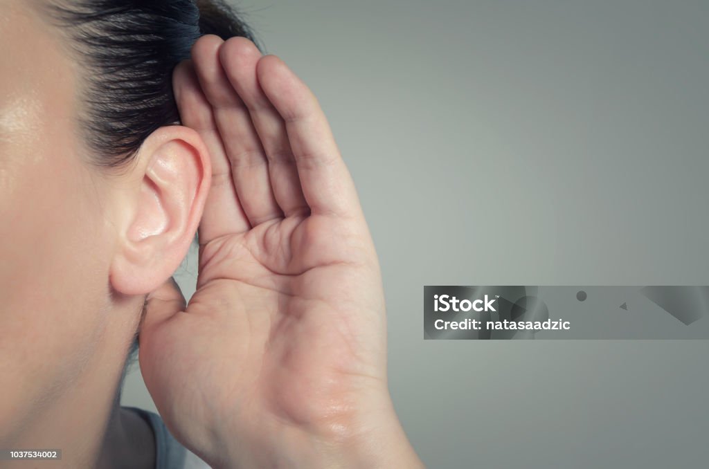 Listening Woman with hand on ear listening for quiet sound or paying attention Listening Stock Photo