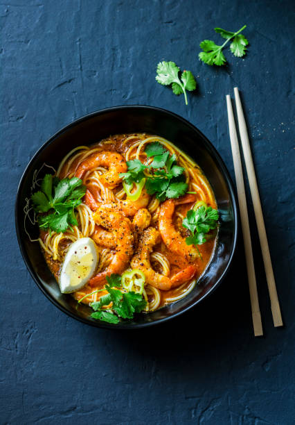 istock Coconut shrimp laksa soup on a dark background, top view. Copy space 1037553972