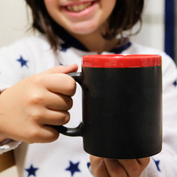 istock girl holding a cup in her hand 1037554302