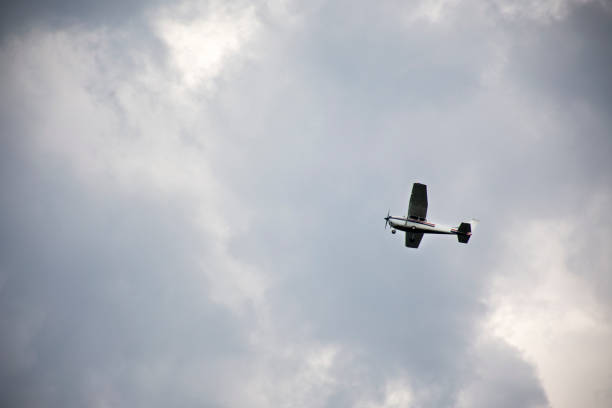 istock Small plane flying in sky with Stormy Clouds 1037558288