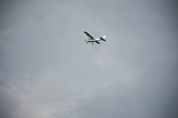 istock Small plane flying in sky with Stormy Clouds 1037558294