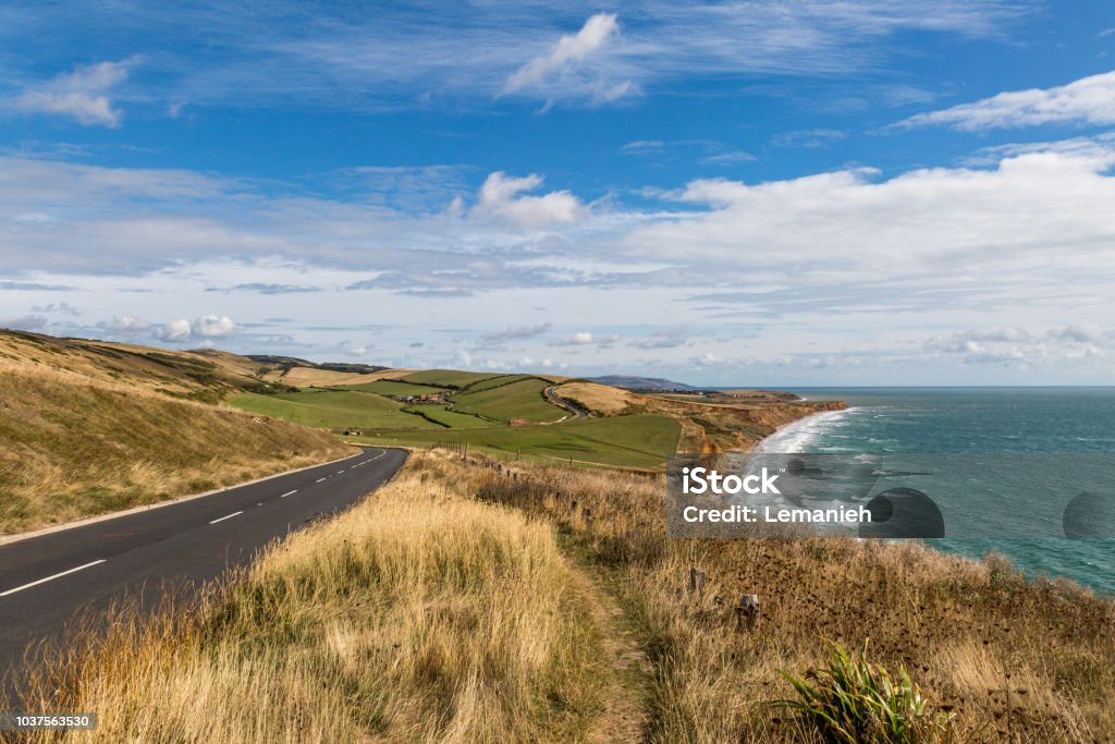 Isle of Wight Coastal Landscape Looking along the coastline of the Isle of Wight towards Compton Bay, with The Military Road running alongside the coastal path Agricultural Field Stock Photo