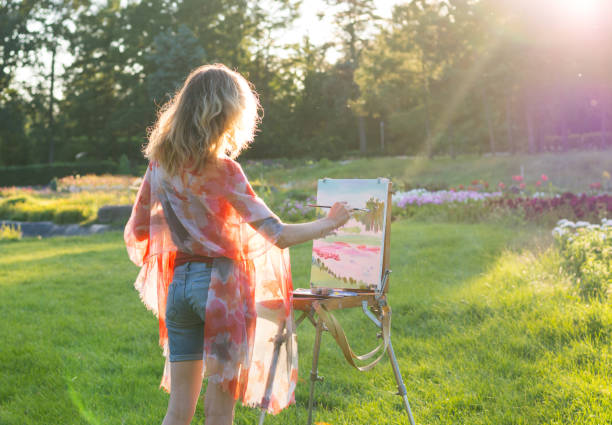 malarz maluje obrazy olejne w ogrodzie o zachodzie słońca - wiatr obrazy zdjęcia i obrazy z banku zdjęć