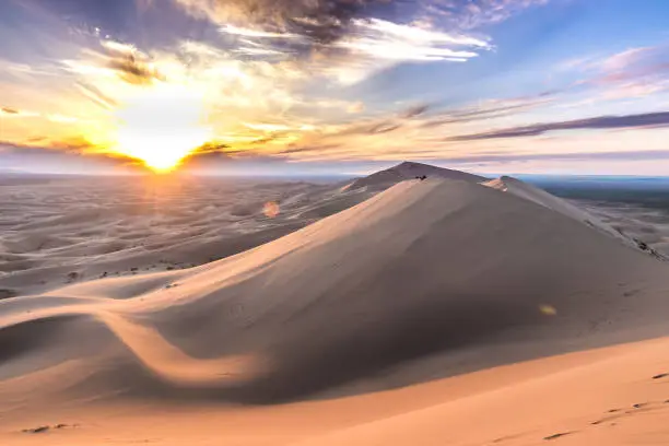 you can see strong sunset, impressive clouds and yellow sand. it is gobi desert in mongol.