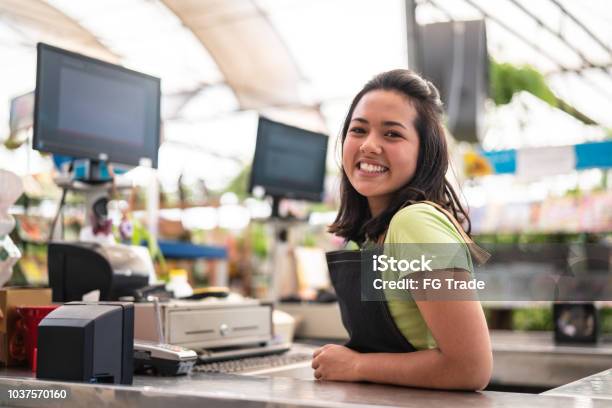 Portrait Of Confident Owner Leaning On Checkout Counter At Flower Shop Stock Photo - Download Image Now