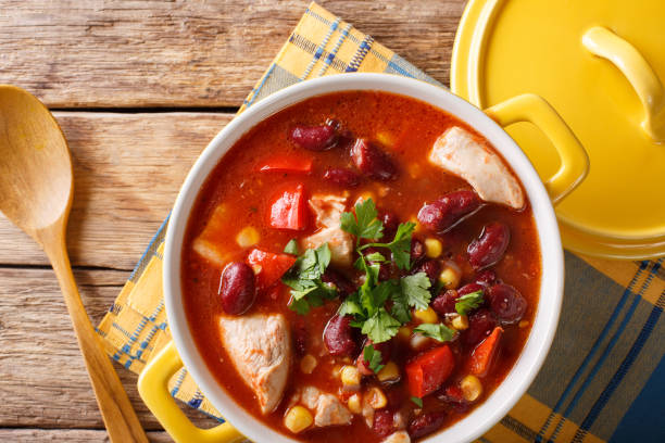 sopa de pollo con close-up chile, frijoles, maíz y tomates en un bol. vista superior horizontal - chili food bowl ready to eat fotografías e imágenes de stock