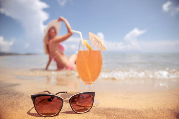 Beautiful woman on the beach, drinking cocktail.Summer time fun.