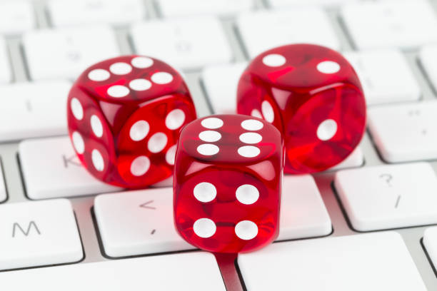 istock Three red dice on keyboard, online casino concept 1037577242