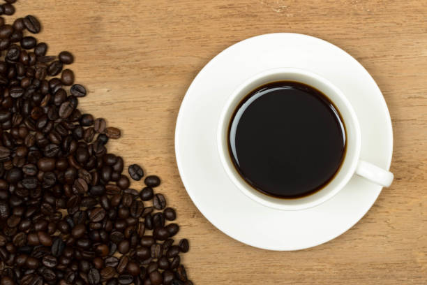 istock Coffee cup on old wooden table with beans 1037585518