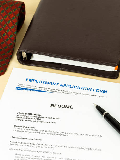 istock Resume with employment application form, pen, neck tie, and notebook 1037585548