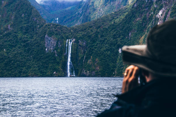 istock Anonymous person taking pictures of waterfall 1037594490