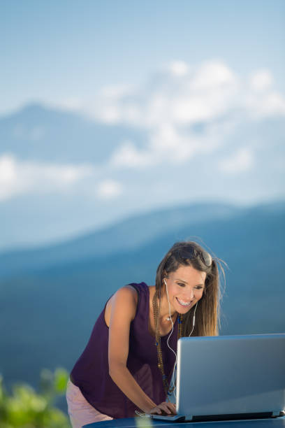 istock Working Outdoors with Technology - Young Lady at a Table with Laptop Outside 1037603640