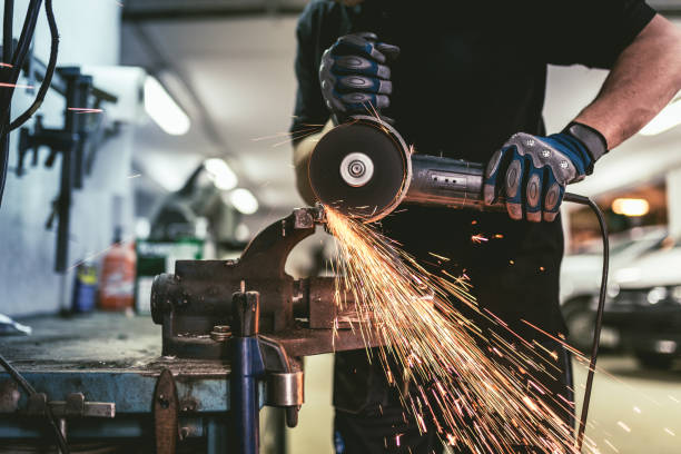 Heavy industry worker cutting steel with an angle grinder. stock photo