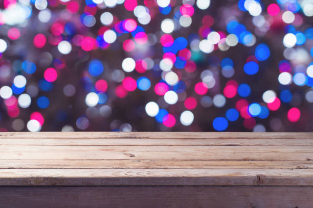 istock Empty wooden table over festive bokeh background. 1037604764
