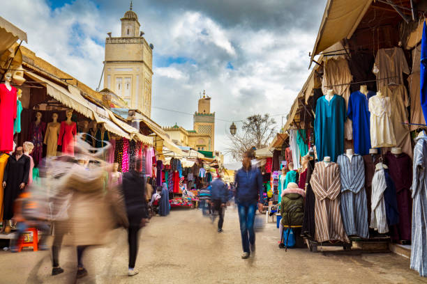 Street Market in the Medina of Fez, Morocco Long exposure image of people walking in street Market at the Medina of Fez, Morocco. fez morocco stock pictures, royalty-free photos & images
