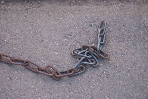 istock The old heavy iron chain lies on the asphalt. 1037614690