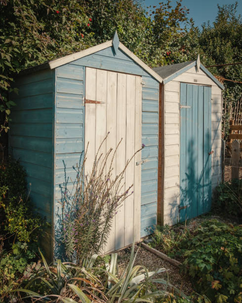 istock Two contrasting blue and white painted garden sheds 1037619870
