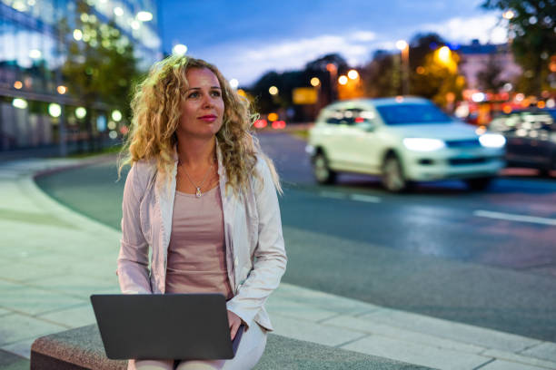 istock Curly female working on laptop outdoor. 1037620000