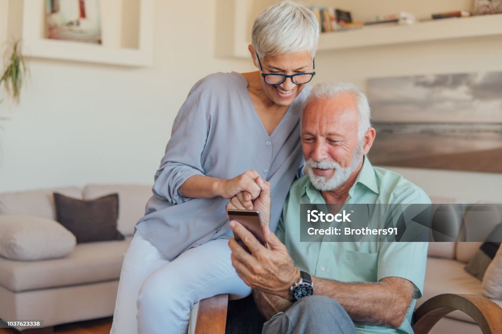 Senior couple using mobile phone Elderly couple with smart phone in their hands Senior Adult Stock Photo