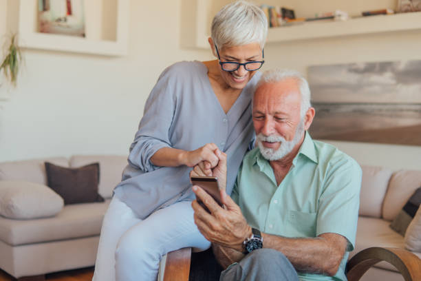 starsza para korzystająca z telefonu komórkowego - couple senior adult cheerful old zdjęcia i obrazy z banku zdjęć