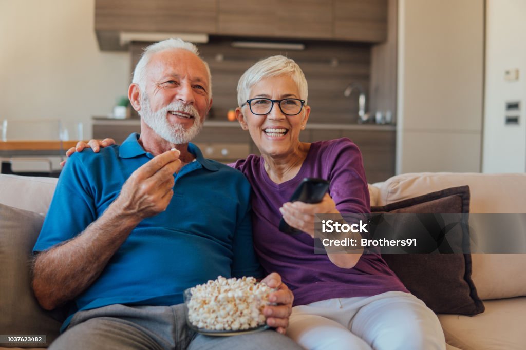 Pareja de jubilados viendo TV - Foto de stock de Mirar la televisión libre de derechos