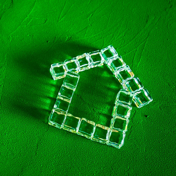 House made of ice cubes on a green background, the concept of real estate and ecology House made of ice cubes on a green background, the concept of real estate and ecology hypothecary stock pictures, royalty-free photos & images